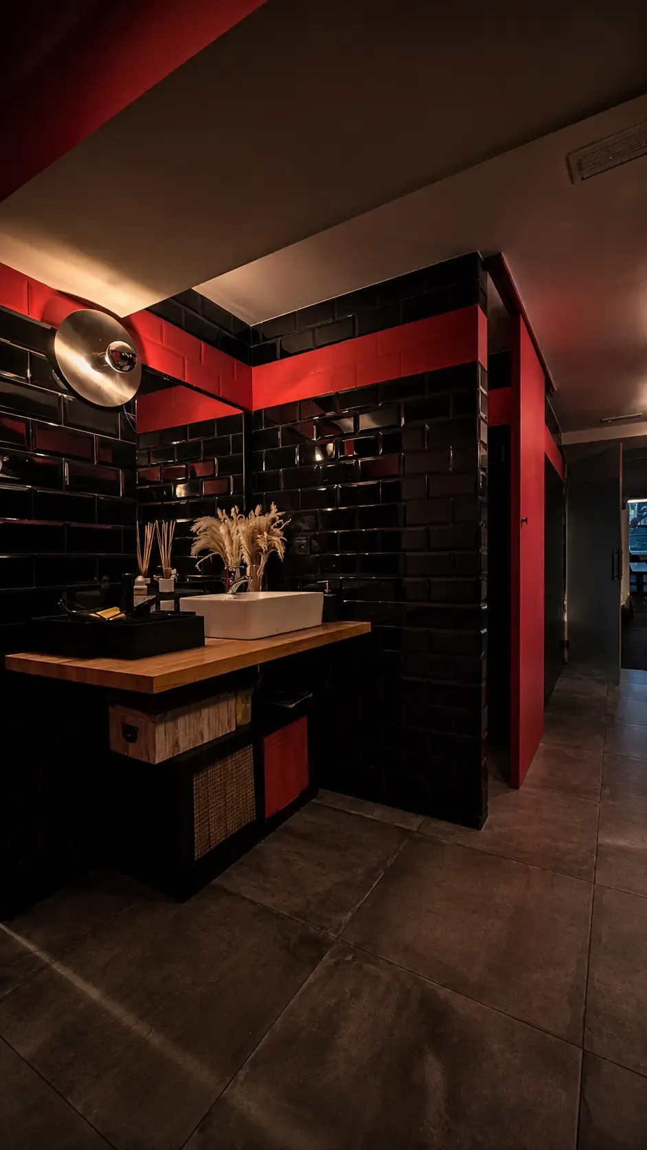 Vestuarios oscuros con azulejos negros y detalles rojos